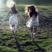 在阳光绿草地中牵手奔跑的女生头像